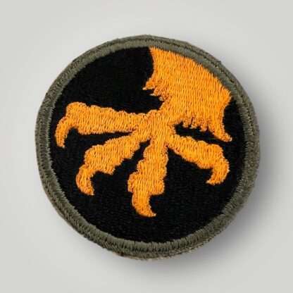 A US WW2 17th Airborne Division Patch, machine embroidered in gold and black thread, with a green rim. The round shaped insignia depicts a golden eagles talons. The division saw action in the Battle of The Bulge and Operation Varsity, and has no damage or repairs in mint condition.