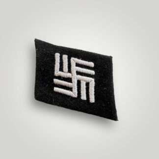 A texbook example of a Waffen-SS Camp Guard collar tab, machine embroidered in white thread on black woollen backing.