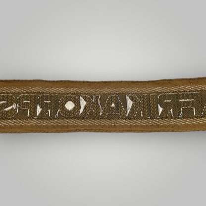 Reverse image of a German Heer AfricaKorp WW2 Cuff Title, machine embroidered with silver aluminum wire, with the inscription AFRIKAKORP.