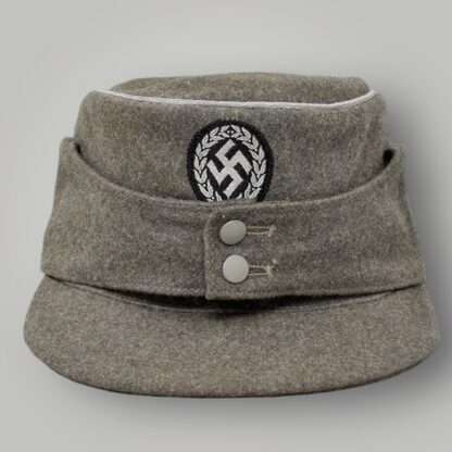 M43 Schutzmannschaft Officer’s Field Cap, constructed in grey field grey wool with aluminium wire piping running around the top of the outer edge of the crown.