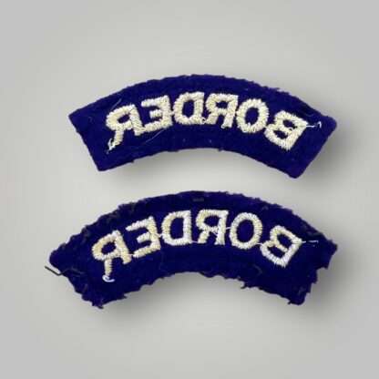 A set of original Border Regiment Cloth Shoulder Titles post-war, machine-embroidered in yellow on green felt with purple backing, in very good condition unissued.