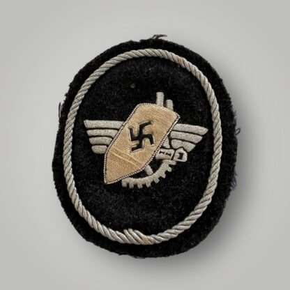 A Werkschutz Factory Guard Officers sleeve badge, oval shaped badge hand embroirered in silver bullion wire on black felt backing.