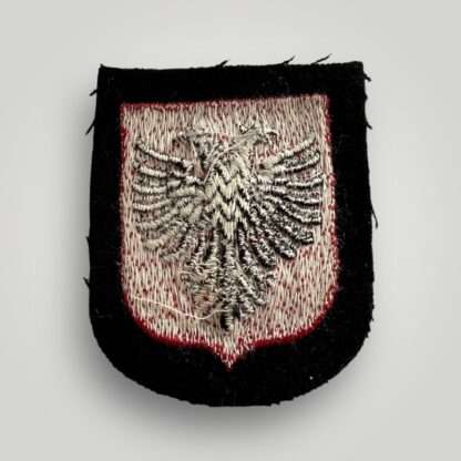 Reverse image of an original Albanian SS Volunteer Sleeve Shield, machine embroidered in red and black thread depicting the Albanian eagle.