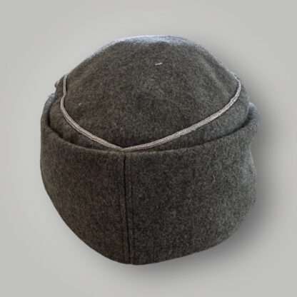 An WW2 German Heer M43 Officers field cap, constructed in grey field grey wool with aluminium wire piping running around the top of the outer edge of the crown.