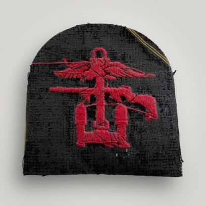Reverse image of a British WW2 Royal Navy / Royal Marines Combined Operations badge, tombstone shaped badge machine embroiderd in red thread on dark blue woollen backing.