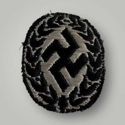 Reverse image of an original Schutzmannschaft Bevo cap badge, flat wire constructionin in silver wire on black rayon backing.