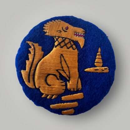 An original Chindit cloth formation badge, machine embroiderd gold, red, and black thread on blue woollen backing.