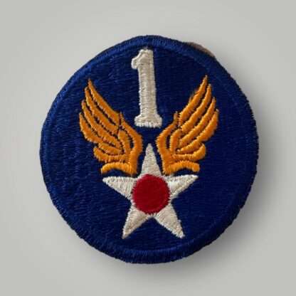 An original 1st USAAF badge, machine embroidered in white, red, and yellow thread on blue backing.