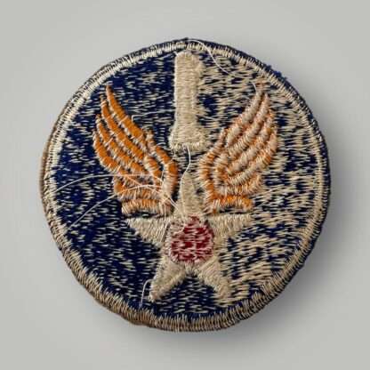 Reverse image of an original 1st USAAF badge, machine embroidered in white, red, and yellow thread on blue backing.