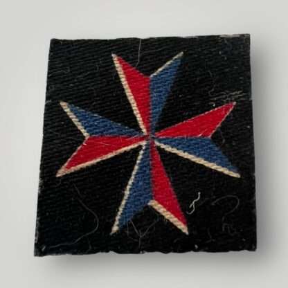 A WW2 British Malta Mobile Units Royal Artillery Formation Badge, machine embroidered in blue and red thread on black backing.