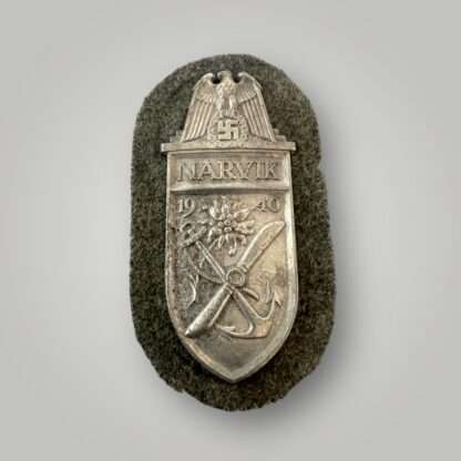 A scarce Heer Narvik campaign shield by Deumer, constructed in zink on field grey woollen backing.