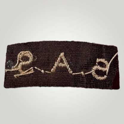 Reverse image of a British Special Air Service WW2 shoulder title, machine embroidered in Cambridge blue thread on maroon woollen backiing.