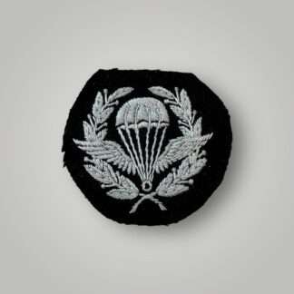 A rare original British Parachute Jump Instructor (PJI) Qualification Badge, machine embroidered in pale blue thread on black wollen backing.
