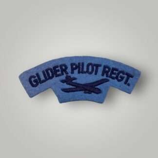 A British Pilot Regiment shoulder title post war circa 1950-57, machine embroidered in dark blue thread on thread on pale blue woollen backing.