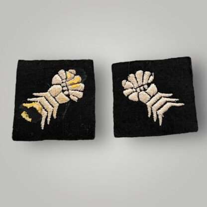 Reverse image of an orginal set of British WW2 6th Armoured Division formation badges, machine embroidered depicting a clenched mailed gauntlet in white on a black woollen square.