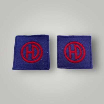 An original set of British WW2 51st Highland Division formation badges, machine embroiderd depicting the letters HD conjoined in red within a red circle on a blue woollen backing.