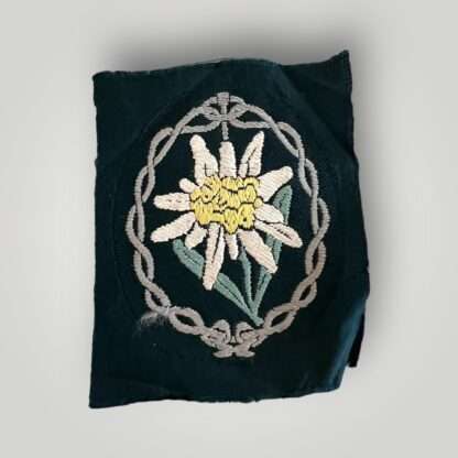 An original Heer Gebirgsjager Edelweiss mountain troops sleeve badge, flat woven BeVo construction on green backing.