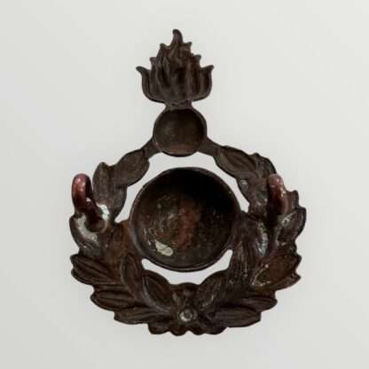 Rear image of an orginal Royal Marines Artillery Sergeants Forage Cap Badge 1921 - 1923, constructed in brass. The badge depicts the classic Royal Marines Globe surrounded by a laurel wreath, surmounted by a grenade fired proper.