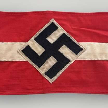 An original Hitler Youth cloth armband, two part construction in red cotton overlaid by a white cotton diamond bearing a black swastika