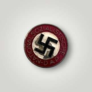 An NSDAP Party pin late war painted badge depicts a roundal with the inscription 'D.A.P. National-Sozialistische' with a painted black swastika in the centre with a white background.