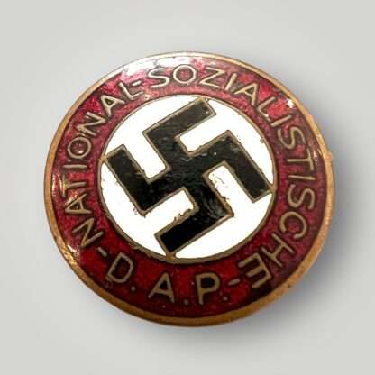 An early NSDAP Party Badge By Schwertner & Cie, Graz, Eggenberg, constructed in red, white, black, and gold enamel.