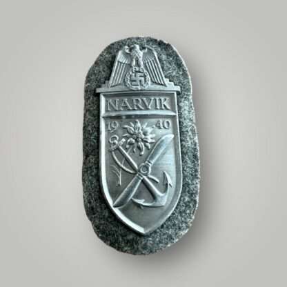 A Heer (Army) Narvik campaign shield by Deumer, constructed in zinc on field grey woollen backing.