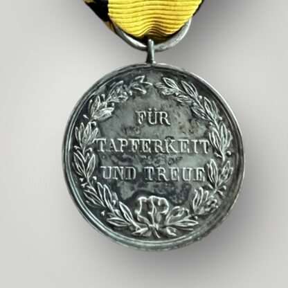 Reverse image of a Wurttemberg Silver Military Merit Medal (Württemberg Militärverdienstmedaille) complete with original ribbon.