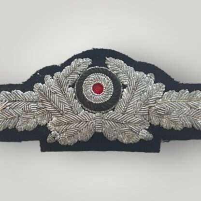 A rare Diplomatic/RMBO officer's bullion visor cap cockade, hand embroidered in silver bullion on dark blue woollen backing padded.