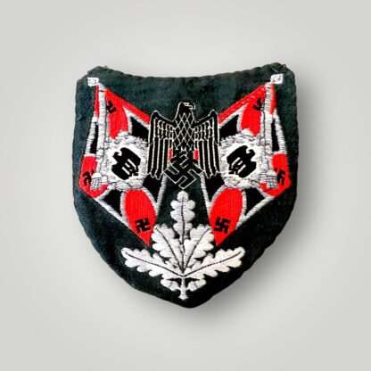 original Heer Artillery Flag Bearers Sleeve Badge, flat Bevo weave construction in red, black, and aluminium thread on green rayon backing.