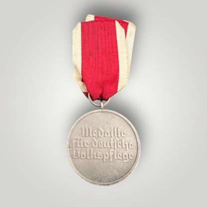 Reverse image of a German WW2 Social Welfare Red Cross Medal, constructed in silver plated bronze with the incription Medaille für deutsche Volkspflege’ (Medal for German Social Welfare).