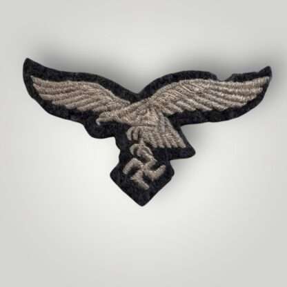 An original WW2 German Luftwaffe EM/NCOs embroidered visor cap eagle, machine embroidered in silver thread on blue woollen backing