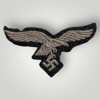 An original WW2 German Luftwaffe EM/NCOs embroidered visor cap eagle, machine embroidered in silver thread on blue woollen backing.