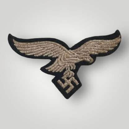 A German WW2 Luftwaffe EM/NCOs embroidered breast eagle, machine embroidered in silver thread on blue woollen backing.