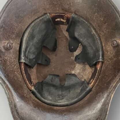 An interior view of a German M16 steel camouflage WW1 helmet with leather liner.