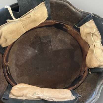 An interior view of a German M16 steel camouflage WW1 helmet with leather liner and pads.