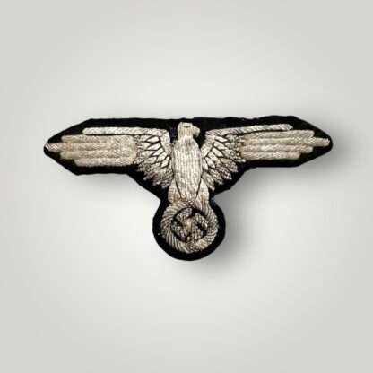 An early Waffen-SS Officers bullion sleeve eagle, hand embroidered in silver bullion on black woollen backing uniform removed.