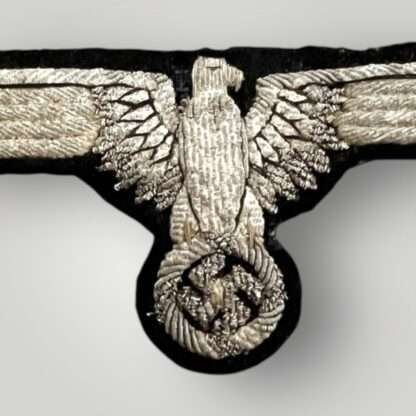 An early Waffen-SS Officers bullion sleeve eagle, hand embroidered in silver bullion on black woollen backing uniform removed.