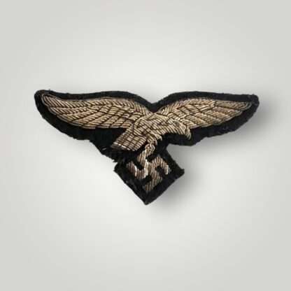 A scarce Luftwaffe Officers Hermann Göring Tunic Breast Eagle machine embroidered in silver bullion wire on black woollen backing.