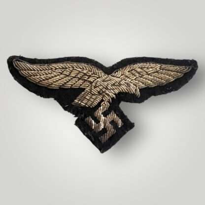 A scarce Luftwaffe Officers Hermann Göring Tunic Breast Eagle machine embroidered in silver bullion wire on black woollen backing.