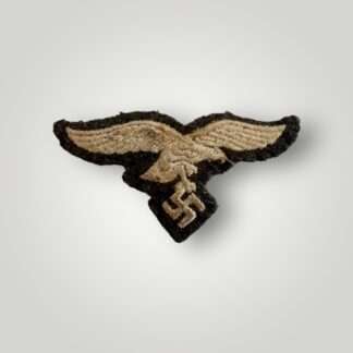 An original WW2 German Luftwaffe EM/NCOs visor cap eagle, machine embroidered in silver thread on blue woollen backing.