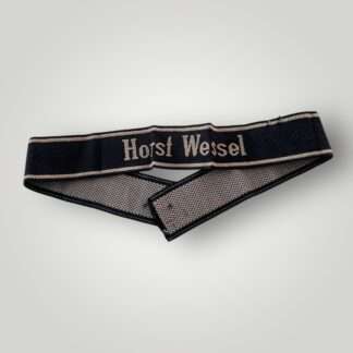 A 18th SS Volunteer Panzergrenadier Division Horst Wessel cufftitle. The insignia is constructed from woven black rayon, with the obverse side trimmed at both the top and bottom with machine-embroidered silver-grey tresses.