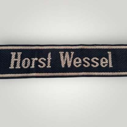 A 18th SS Volunteer Panzergrenadier Division Horst Wessel cufftitle. The insignia is constructed from woven black rayon, with the obverse side trimmed at both the top and bottom with machine-embroidered silver-grey tresses.