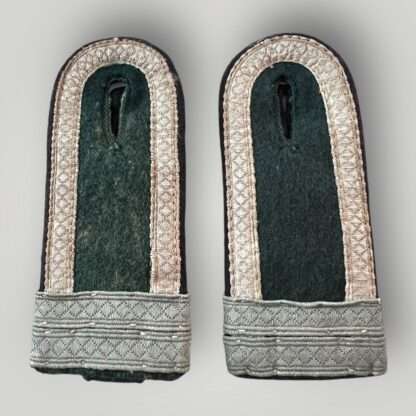 A matching pair of Heer M44 Pioneer Fahnenjunker Unteroffizier shoulder boards, constructed on dark green wool with diamond patterned matt blue/grey tress on the outer edge, with two horizontal tress strips denothing the rank of Fahnenjunker Unteroffizier with black rayon waffenfarbe piping for pionner troops