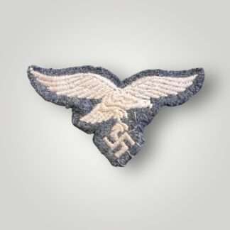 An original WW2 German Luftwaffe EM/NCOs visor cap eagle, machine embroidered in silver thread on blue woollen backing.