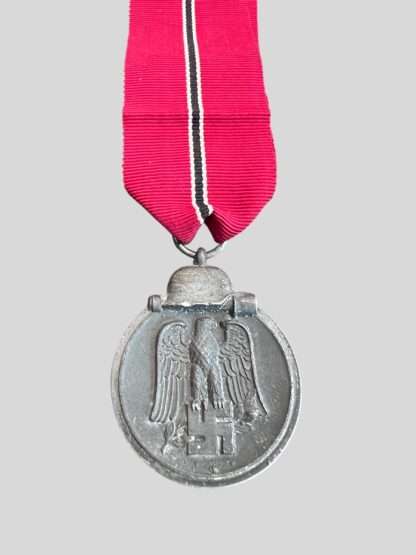 An original WW2 German Eastern Front Medal unknown maker, constructed in zinc complete with suspension ring which is unmarked with a nice long ribbon.