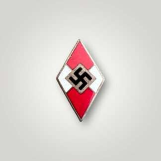 A genuine HJ membership badge M1/42,  constructed from a die-struck base alloy with red, white, and black enamel.