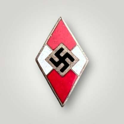 A genuine HJ membership badge M1/42,  constructed from a die-struck base alloy with red, white, and black enamel.