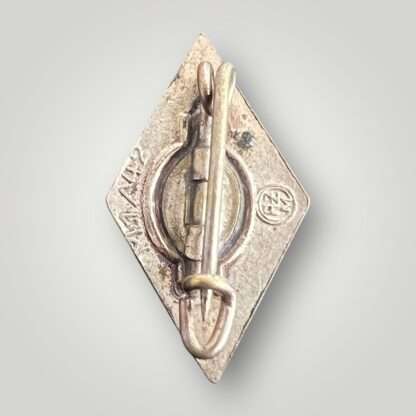Reverse image of a HJ membership badge marked M1/42,  constructed from a die-struck base alloy.
