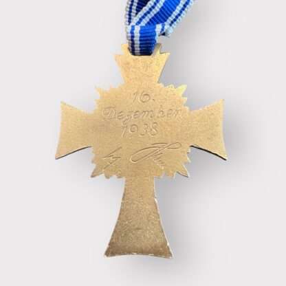 Reverse image of an orginal German Mother's Cross Gold with the inscription 16 December 1938 and Adolf Hitlers Signature.