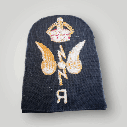 Reverse image of an original British Royal Navy WW2 Wireless Telegraphist & Radar Trade Badge, machine embroidered with yellow and red thread on dark blue wool.